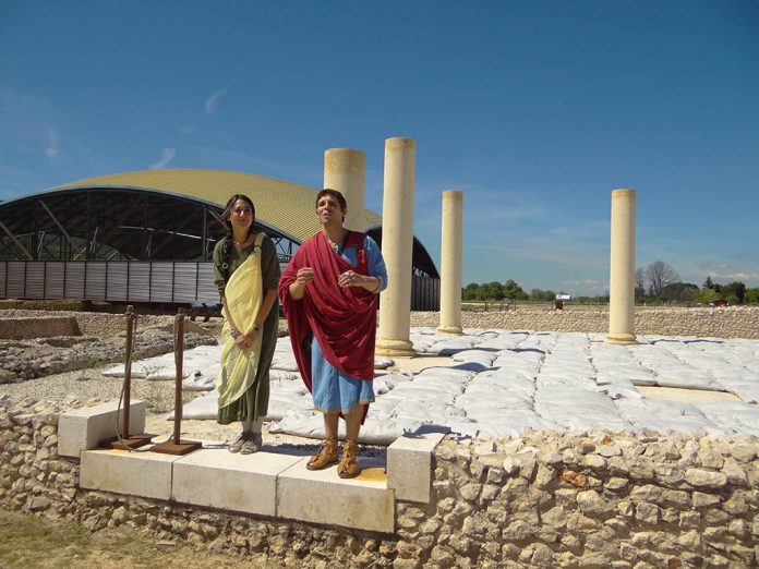 Gayo Annio y Terencia Antilia, un matrimonio de la época, basado en personajes que realmente vivieron en Complutum, y al fondo la cúpula metálica de la Casa de los Grifos